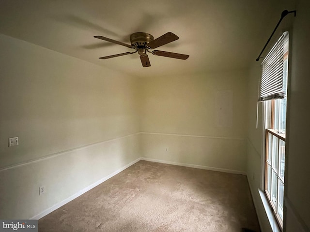 carpeted spare room featuring ceiling fan