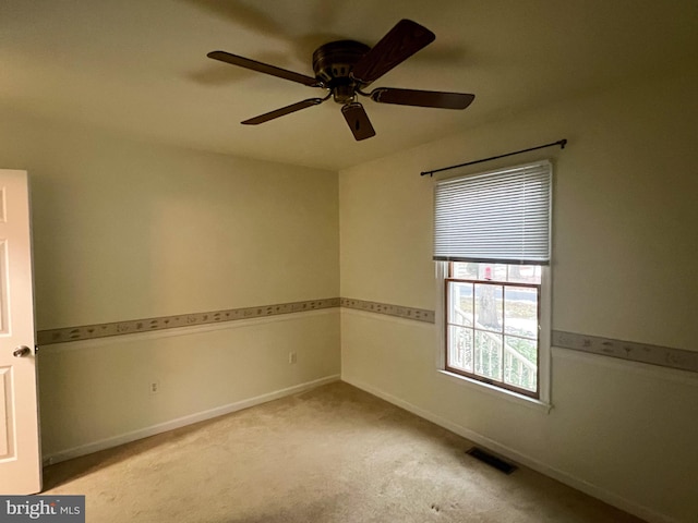 carpeted spare room with ceiling fan