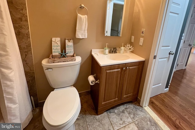 bathroom with toilet, vanity, and hardwood / wood-style flooring