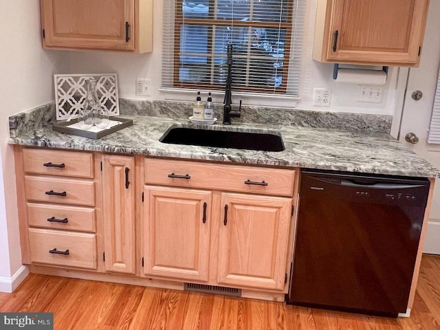 kitchen with light wood-type flooring, black dishwasher, light brown cabinets, and sink