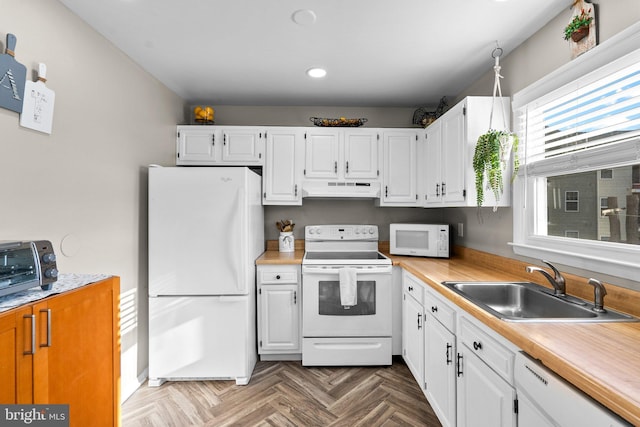 kitchen with white cabinetry, parquet flooring, white appliances, and sink