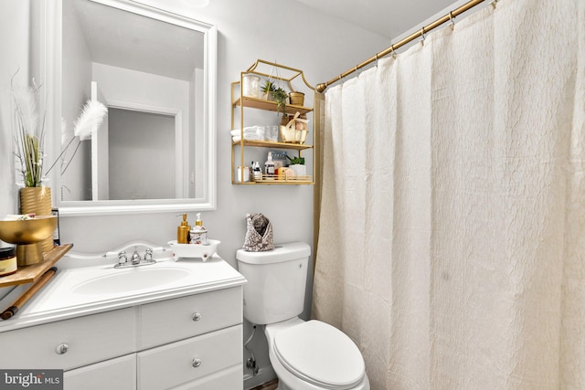 bathroom with toilet, vanity, and curtained shower