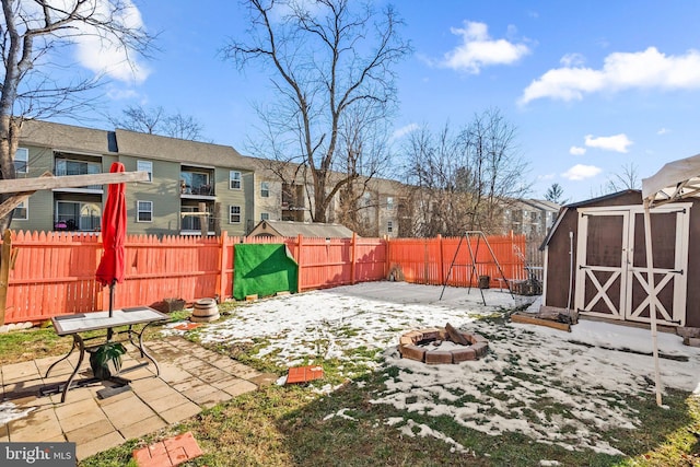 view of yard with an outdoor fire pit, a storage unit, and a patio