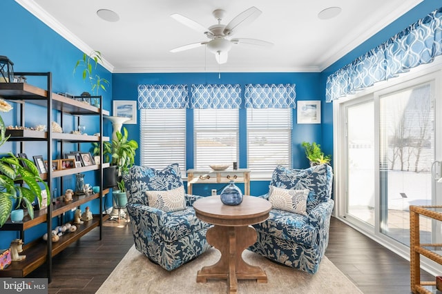 living area with ceiling fan, dark hardwood / wood-style floors, and ornamental molding