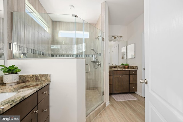 bathroom with vanity and a shower with door