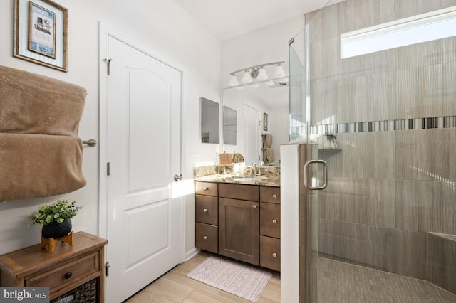 bathroom featuring a shower with shower door, wood-type flooring, and vanity