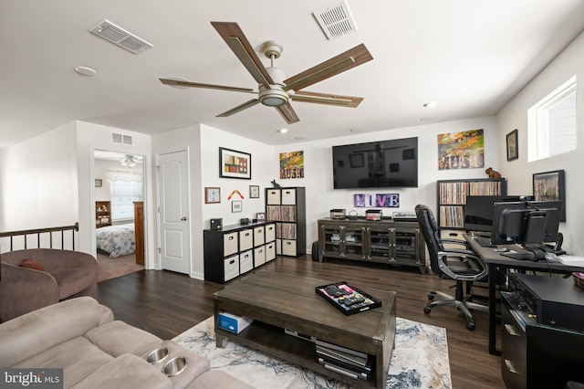 living room featuring ceiling fan and dark hardwood / wood-style floors