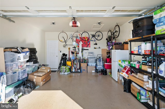 garage with white fridge and a garage door opener