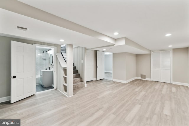 basement featuring sink and light wood-type flooring