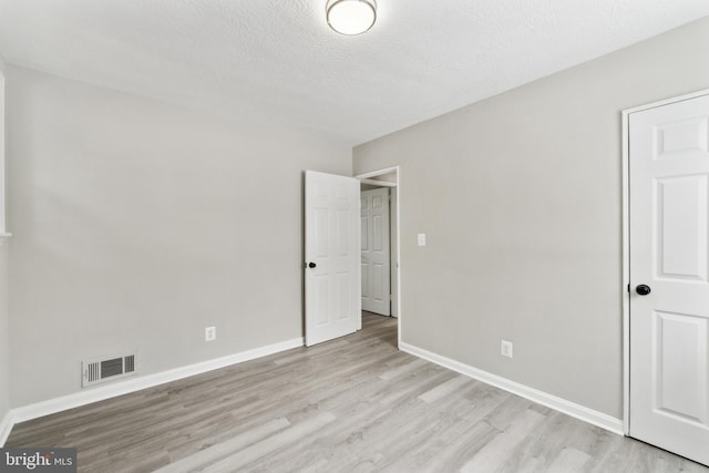 unfurnished bedroom featuring a textured ceiling and light wood-type flooring