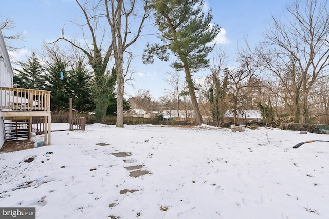 snowy yard with a wooden deck