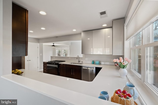 kitchen featuring dark brown cabinetry, a sink, white cabinetry, light countertops, and stainless steel dishwasher