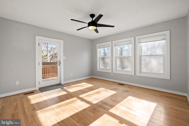 unfurnished room with baseboards, visible vents, and light wood-style floors