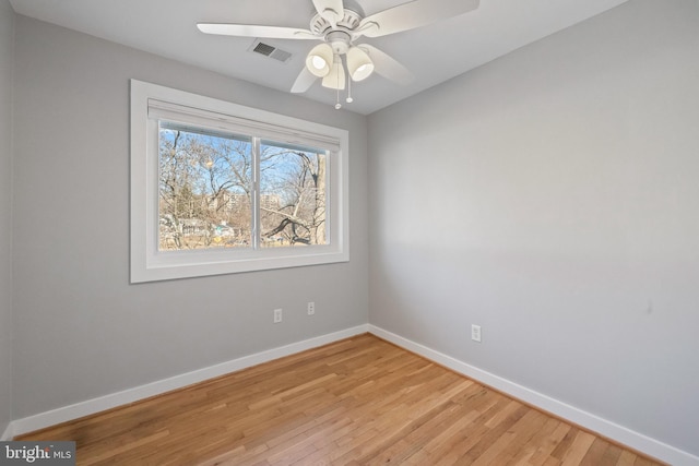 empty room featuring a ceiling fan, baseboards, visible vents, and light wood finished floors