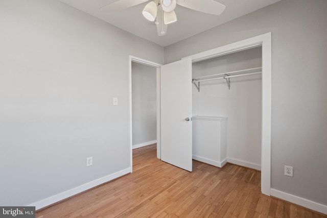 unfurnished bedroom with light wood-type flooring, a ceiling fan, baseboards, and a closet