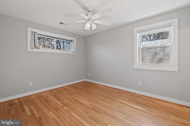 unfurnished room with visible vents, ceiling fan, light wood-style flooring, and baseboards