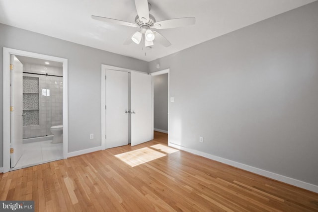 unfurnished bedroom featuring ceiling fan, connected bathroom, light wood-style flooring, baseboards, and a closet