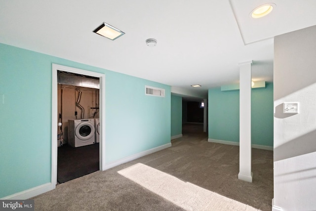 unfurnished room featuring washer and dryer, baseboards, visible vents, and carpet flooring