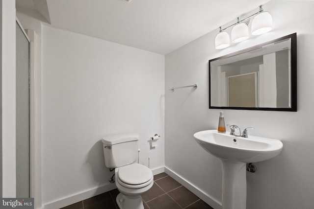 bathroom with tile patterned flooring, toilet, and baseboards