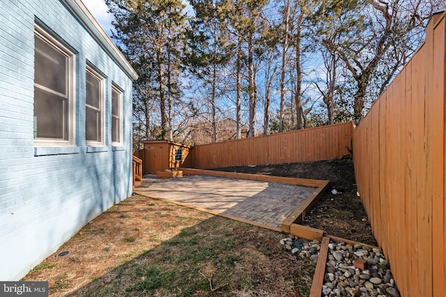 view of yard with a patio, a shed, an outdoor structure, and a fenced backyard