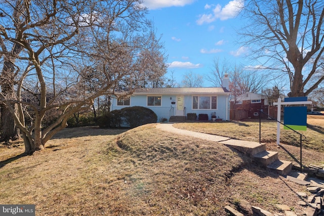 ranch-style home featuring a front yard, fence, and a chimney