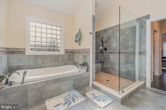 bathroom featuring tile patterned floors, lofted ceiling, and shower with separate bathtub