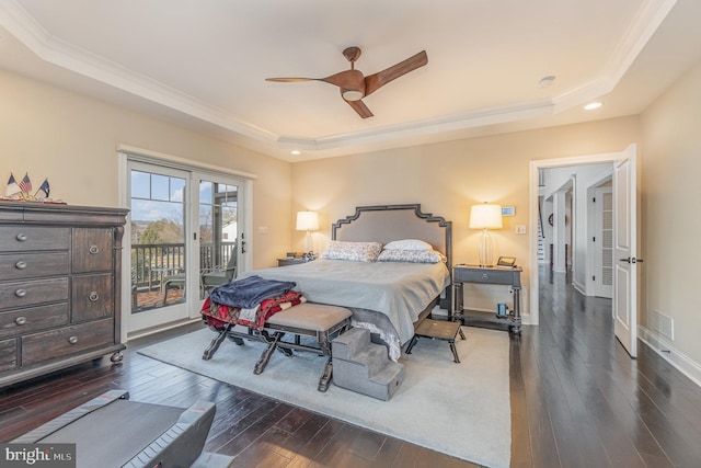 bedroom featuring ceiling fan, a tray ceiling, dark hardwood / wood-style floors, and access to outside