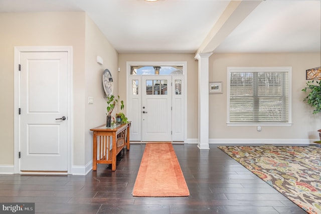 entryway featuring dark hardwood / wood-style flooring and decorative columns