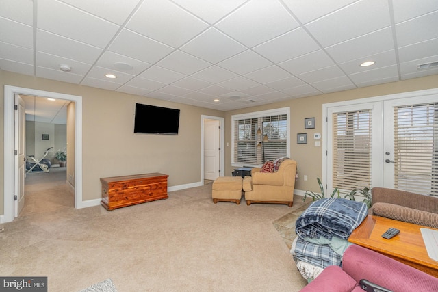 living room with a paneled ceiling and carpet flooring