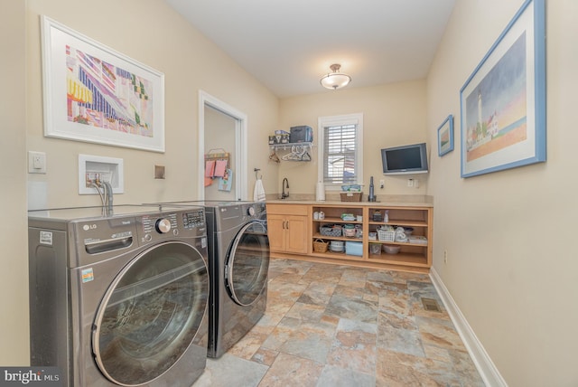 clothes washing area featuring cabinets, sink, and independent washer and dryer