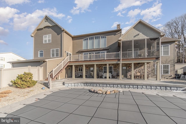 back of house featuring a sunroom, a pool side deck, and a patio