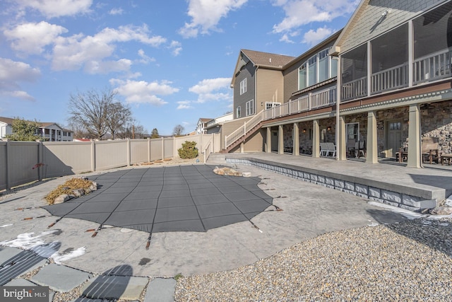 view of swimming pool featuring a sunroom and a patio