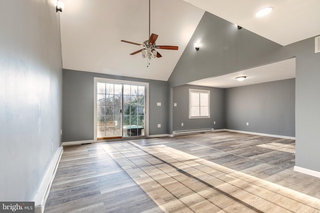 spare room featuring high vaulted ceiling, baseboard heating, light wood-type flooring, and ceiling fan