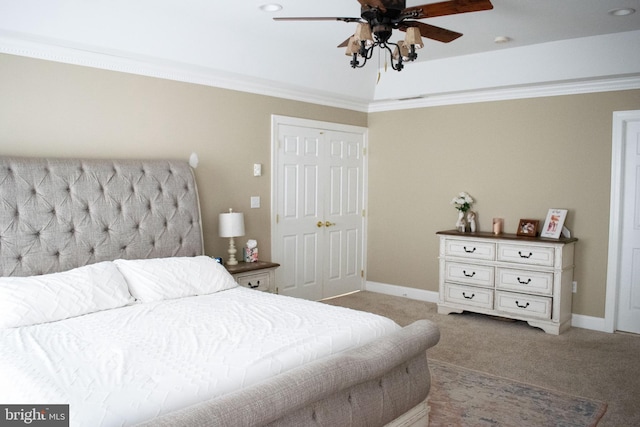 carpeted bedroom with ceiling fan, a closet, and crown molding