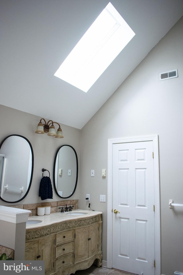 bathroom featuring vanity and vaulted ceiling with skylight