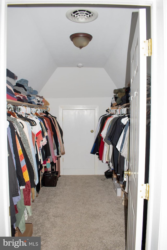 spacious closet featuring vaulted ceiling and carpet flooring