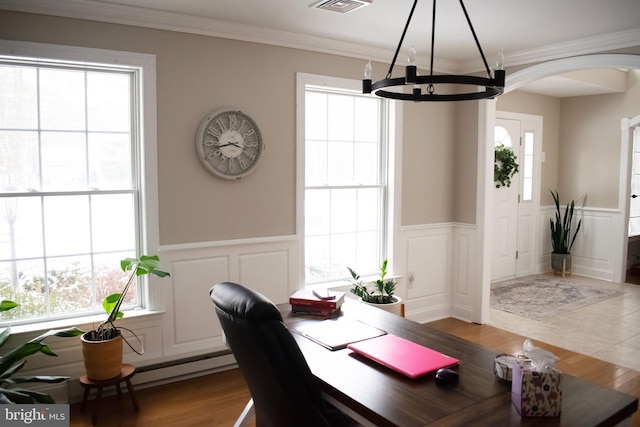 dining area featuring an inviting chandelier, crown molding, and wood-type flooring