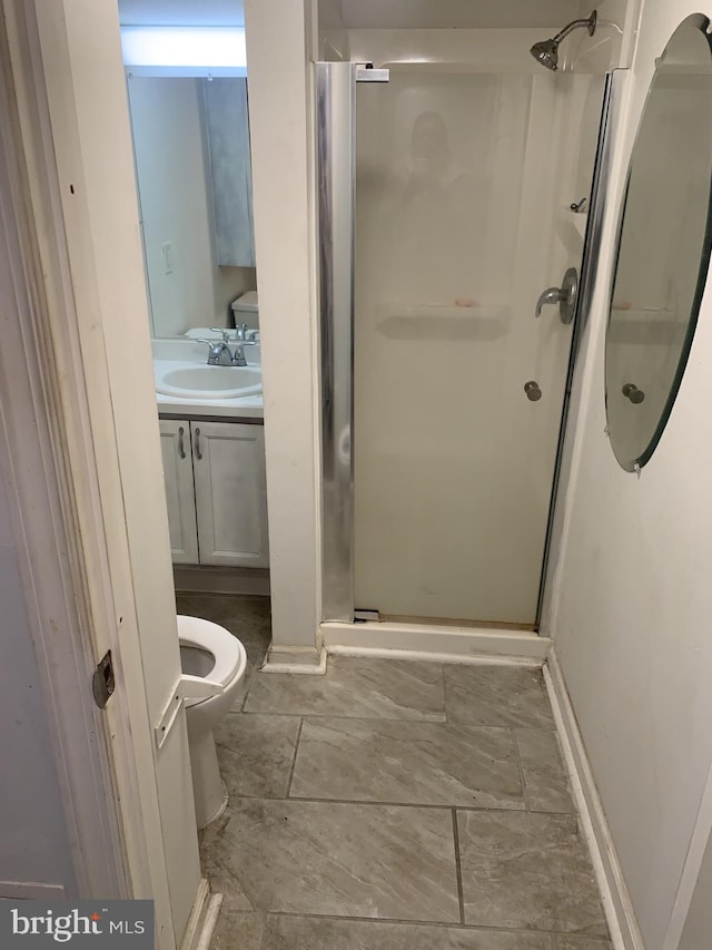 bathroom featuring toilet, walk in shower, and vanity