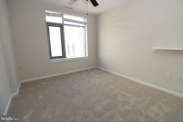 unfurnished room with ceiling fan, a wealth of natural light, and carpet