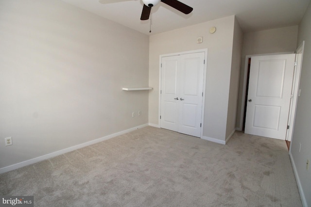 unfurnished bedroom with ceiling fan, light colored carpet, and a closet