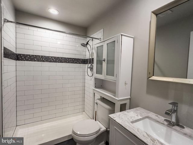 bathroom featuring vanity, toilet, and a tile shower