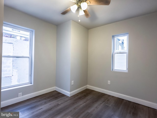 empty room featuring dark wood-type flooring, plenty of natural light, and ceiling fan