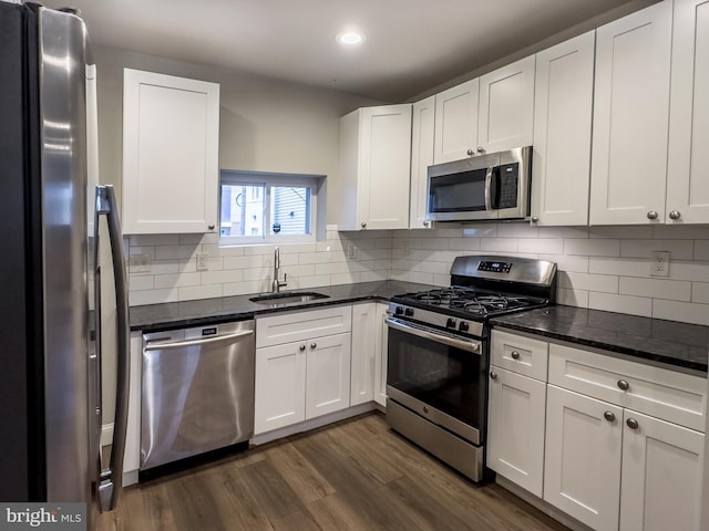 kitchen featuring white cabinetry, appliances with stainless steel finishes, dark hardwood / wood-style floors, and sink