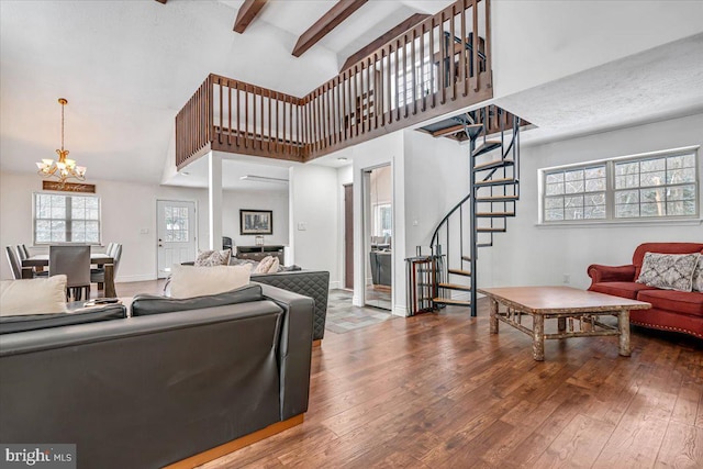 living room featuring hardwood / wood-style flooring, a high ceiling, beam ceiling, and a notable chandelier