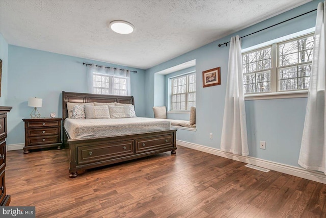 bedroom with dark wood-type flooring and a textured ceiling