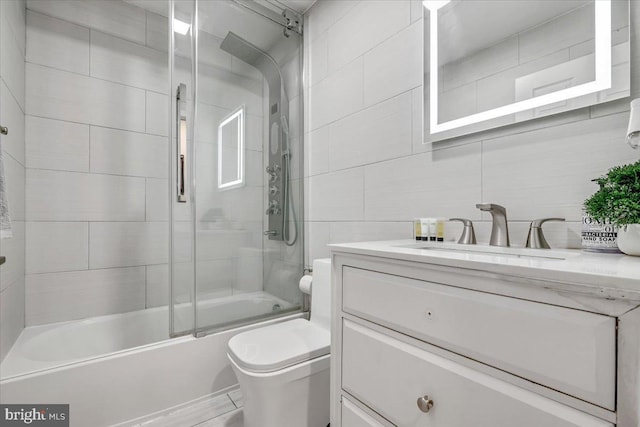 full bathroom with toilet, vanity, tile walls, and enclosed tub / shower combo