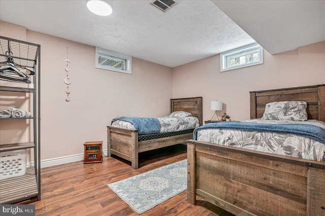 bedroom featuring a textured ceiling and hardwood / wood-style flooring