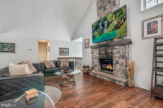 living room featuring a fireplace, hardwood / wood-style floors, and high vaulted ceiling