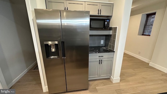 kitchen featuring light wood-type flooring, stainless steel refrigerator with ice dispenser, and tasteful backsplash