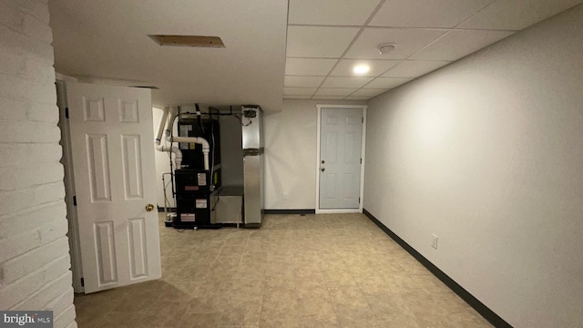 basement featuring heating unit and a paneled ceiling